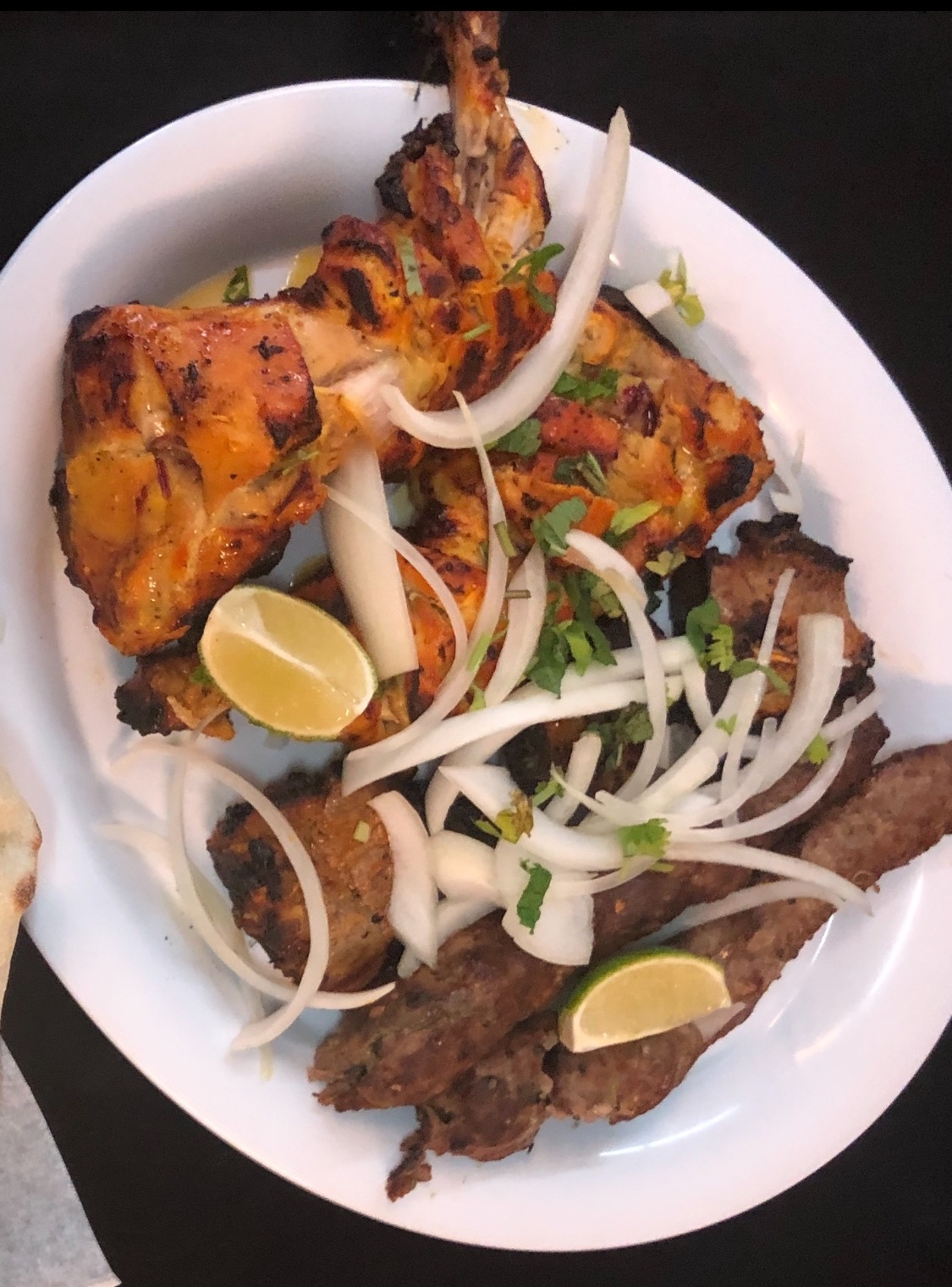 Platter of sizzling Seekh Kababs and seasoned rice served at Lahori Restaurant.